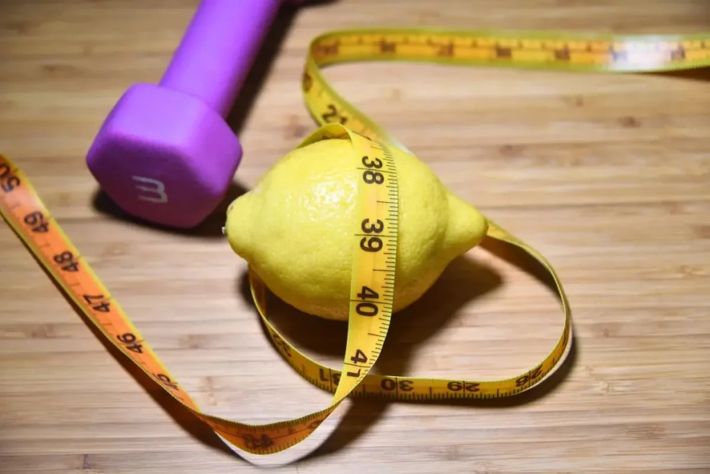 Citron entouré d’un ruban à côté d’un poids de sport.
