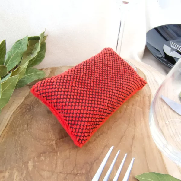Éponge lavable rouge avec de la vaisselle.