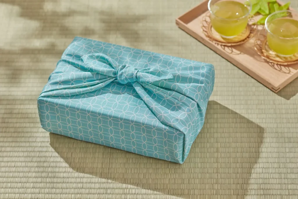 Cadeau emballé dans un furoshiki bleu.