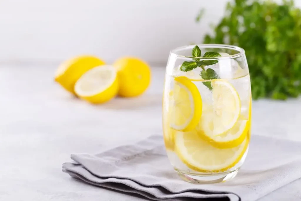 Verre d’eau citronnée avec des tranches de citron.